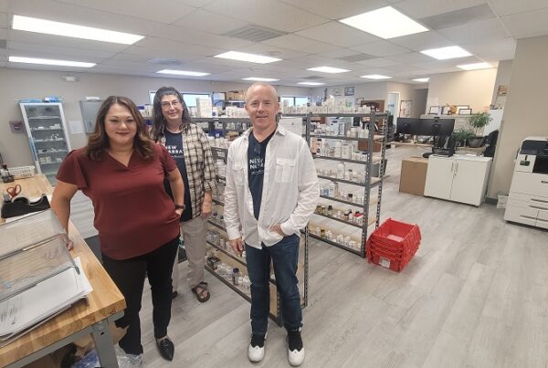 Three pharmacy staff pose in the New Narrative pharmacy.