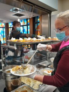 Two Bridgeview Staff prepare to serve residents with a meal
