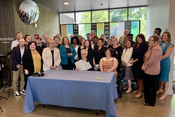 Governor Kotek poses with providers and advocates holding the signed bills