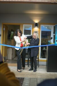 CEO Julie Ibrahim and Commissioner Meieran cut the blue ribbon in front of the apartments