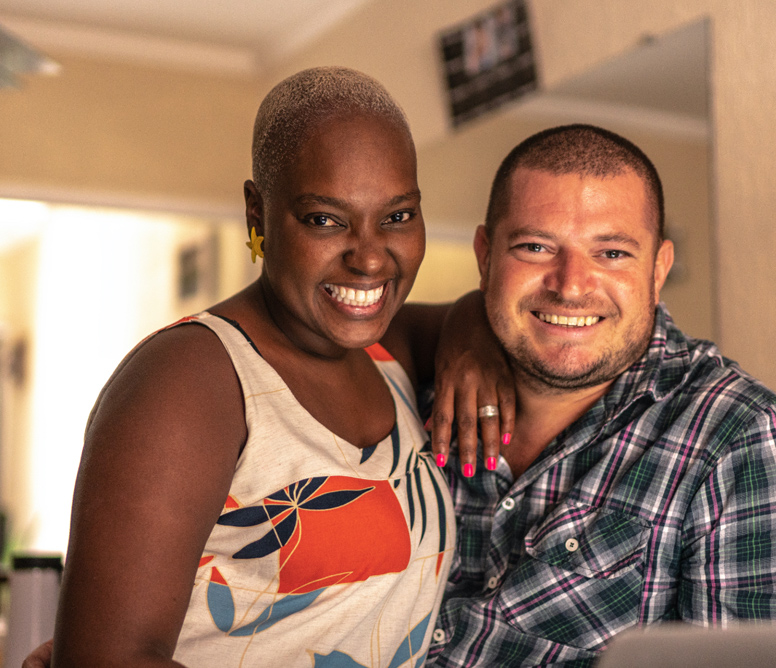 two people-a Black woman and multiethnic man face the camera smiling